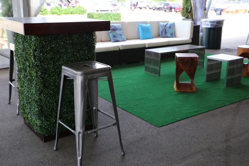 Tables and a green carpet for an outdoor event.